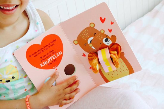 Kind dat een boek vasthoudt met een bruine beer en pluche poten. Een hartvormige tekstballon is zichtbaar.