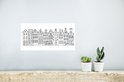 Zwart-wit poster met Amsterdamse huisjes, op een lichte muur.