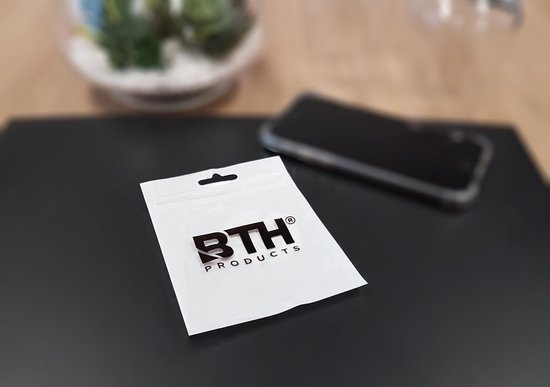 Witte verpakking met het BTH PRODUCTS logo, met een telefoon en plant op de achtergrond.