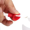 Een hand die de rode siliconen punt van een witte flessenschraper vasthoudt.