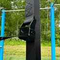 Close-up van de zwarte gesp van een verstelbare ophangband voor gymringen.