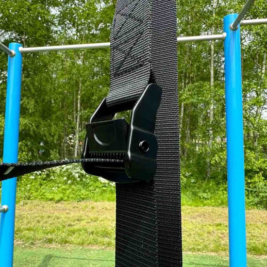 Close-up van de zwarte gesp van een verstelbare ophangband voor gymringen.
