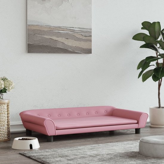 Canapé pour chien en velours rose dans un salon avec décoration.
