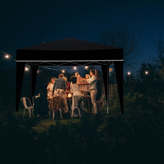 Zwarte partytent met verlichting, verjaardagviering met vrienden en familie aan een gedekte tafel in de tuin.