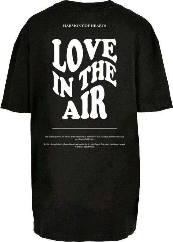 Zwarte oversized T-shirt met "LOVE IN THE AIR" en 'HARMONY OF HEARTS' in witte letters op de achterkant.