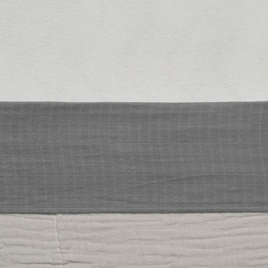 Gestreept baby ledikantlaken in wit, grijs en beige. De stoffen hebben een gekreukelde textuur.