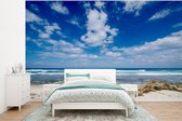 Behang - Fotobehang Blauwe lucht met wolken op strand van Isla Mujeres in Mexico - Breedte 375 cm x hoogte 280 cm