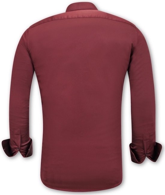 Dos d'une chemise bordeaux en satin, coupe ajustée. Manches retroussées.