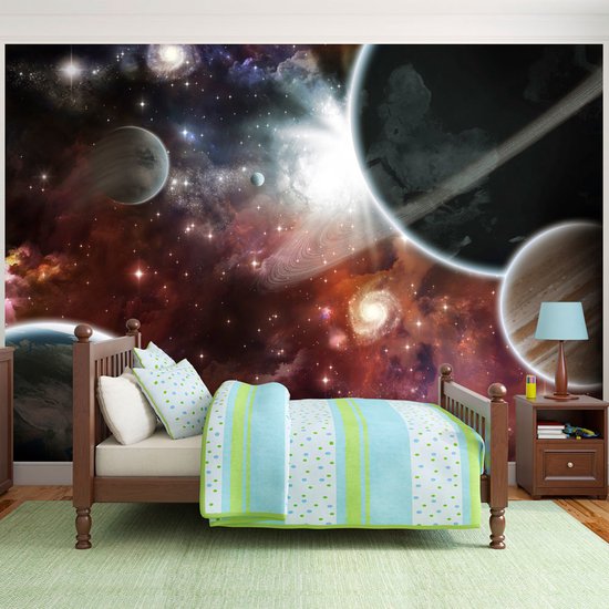 Une chambre d'enfant avec une fresque murale de l'espace, comprenant un lit et une table de chevet.