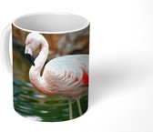 Mok - Een flamingo staat in het water voor de rotsen - 350 ML - Beker