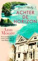 Boek "Achter de horizon" van Ann Moore. Titel Grace O'Malley 3. Een moedige Ierse vrouw geeft alles op voor haar vrijheid. Rechts iconische huizen, links een dramatische kustlijn met groen en golven.