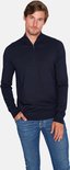 Man met donkerblauwe trui met rits tot de borst, jeans en bruine schoenen.
