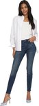 Model van achteren in een donkerblauwe skinny jeans met een witte blouse.