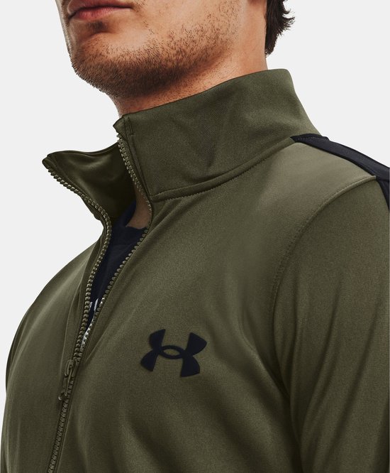 Gedetailleerde close-up van de kraag en rits van een groen Under Armour trainingsjack met zwart logo.