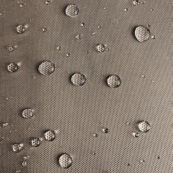 Waterdruppels op een beige beschermhoes met een geweven textuur.