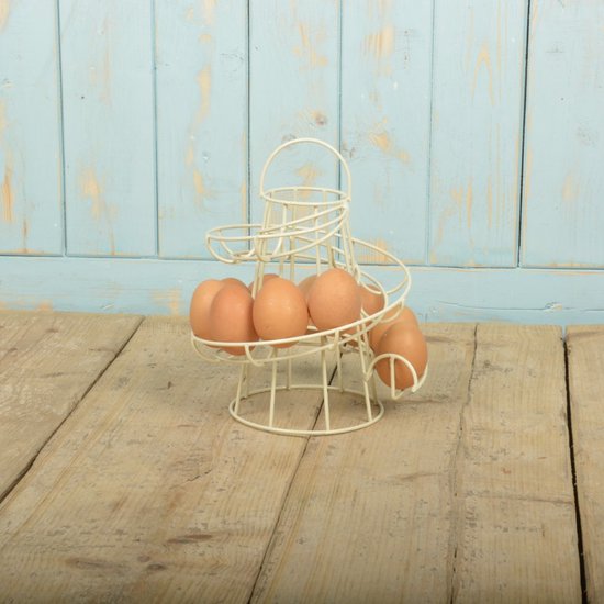 Crèmekleurig metalen spiraal eierrek met 7 bruine eieren, op houten ondergrond voor blauw houten schot.