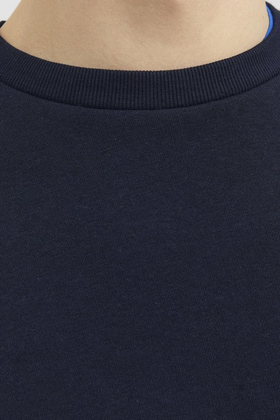 Detail van de ronde hals van een donkerblauwe sweater.