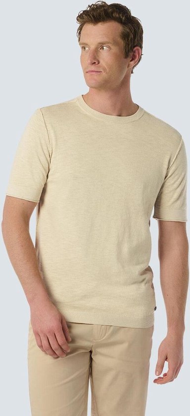 Homme portant un t-shirt beige à manches courtes et un pantalon chino clair.